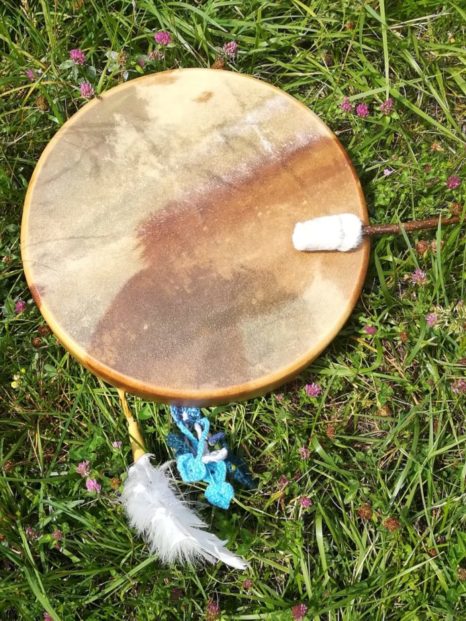 tambour chamanique dans l'herbe avec plume
